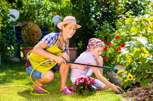 Gardener wearing PPE while trimming a hedge